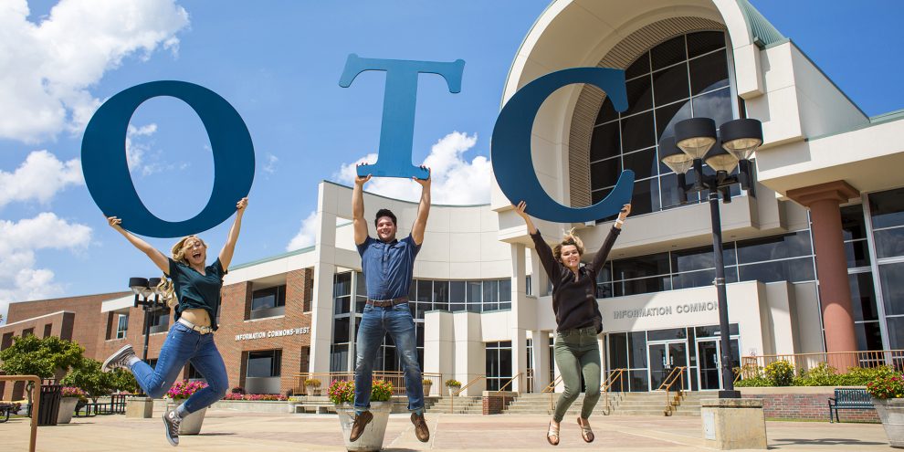 Student ambassadors jumping on the plaza holding the OTC Letters.