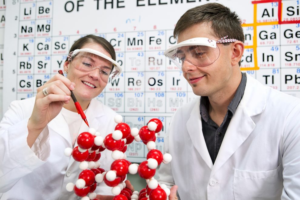 Chemistry students studying a molecular structure.