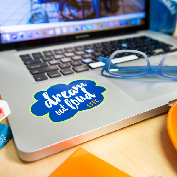 OTC study spread with the "Dream Out Loud" tech tatto on the computer.