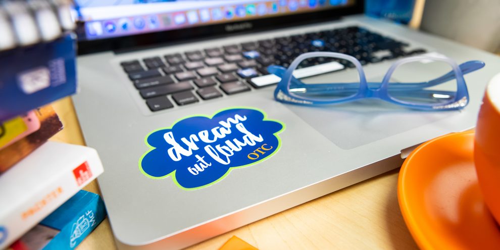 OTC study spread with the "Dream Out Loud" tech tatto on the computer.