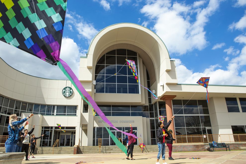 Students flying kites on the plaza in front of Information Commons.