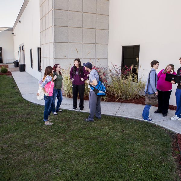 Lebanon Education Center students stand outside of Casey Hall, talking.