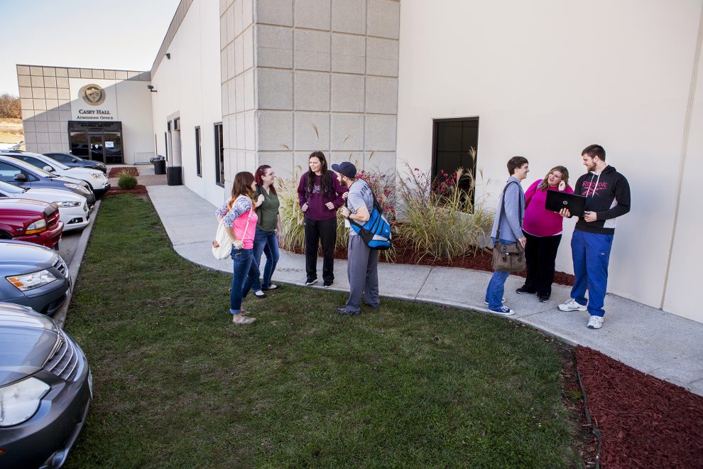 Lebanon Education Center students stand outside of Casey Hall, talking.