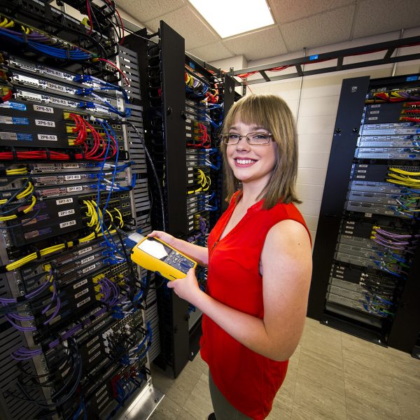 A Networking Technology Program student tests cables in the server room.