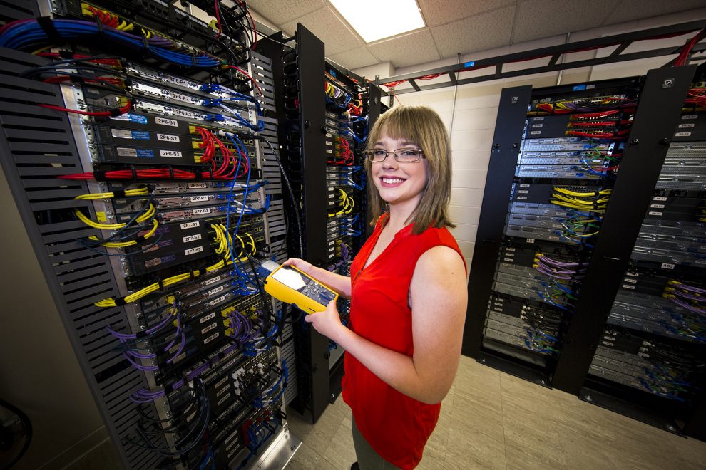A Networking Technology Program student tests cables in the server room.