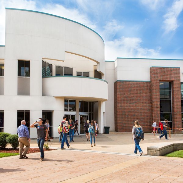 Students and employees walking in front of Norman K Meyers building.
