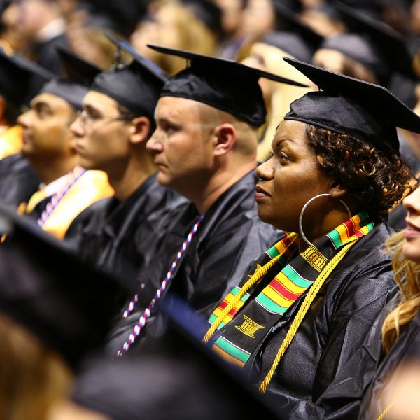 OTC graduates in regalia listen to the commencement speaker.