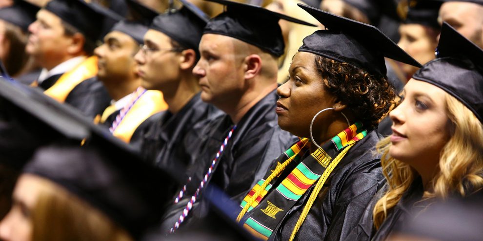 OTC graduates in regalia listen to the commencement speaker.