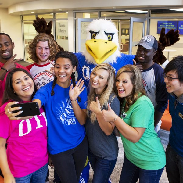 Ozzy and students pose for a selfie in the Welcome Center.