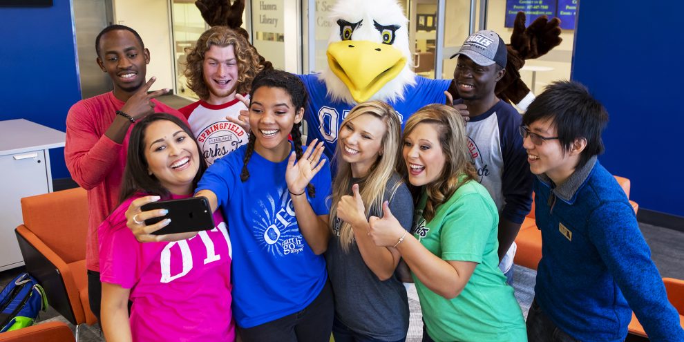 Ozzy and students pose for a selfie in the Welcome Center.
