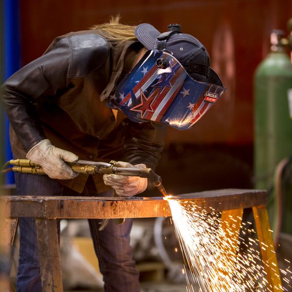 Welding Technology Program student cutting metal.